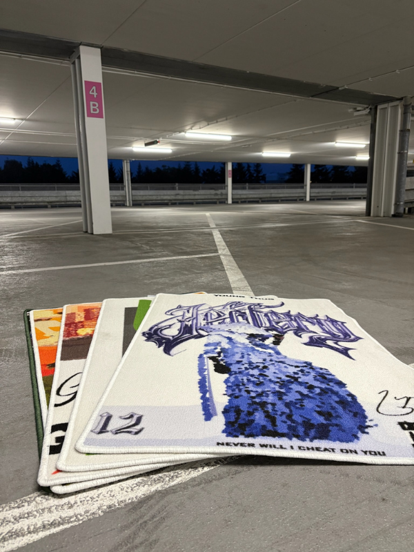 Rugs – stacked fan (garage) Rugs stacked as a small fan in a parking garage; tightly layered designs with the JEFFERY piece standing out