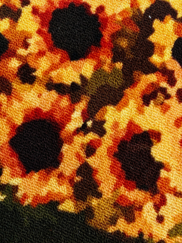 Flower Boy rug, sunflower close-up in pixel design, color blocks and fiber texture visible